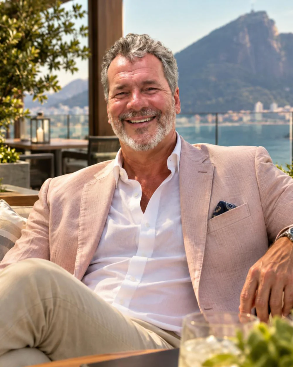 Paulo Fernandes sentado em um terraço com vista para a orla do Rio de Janeiro